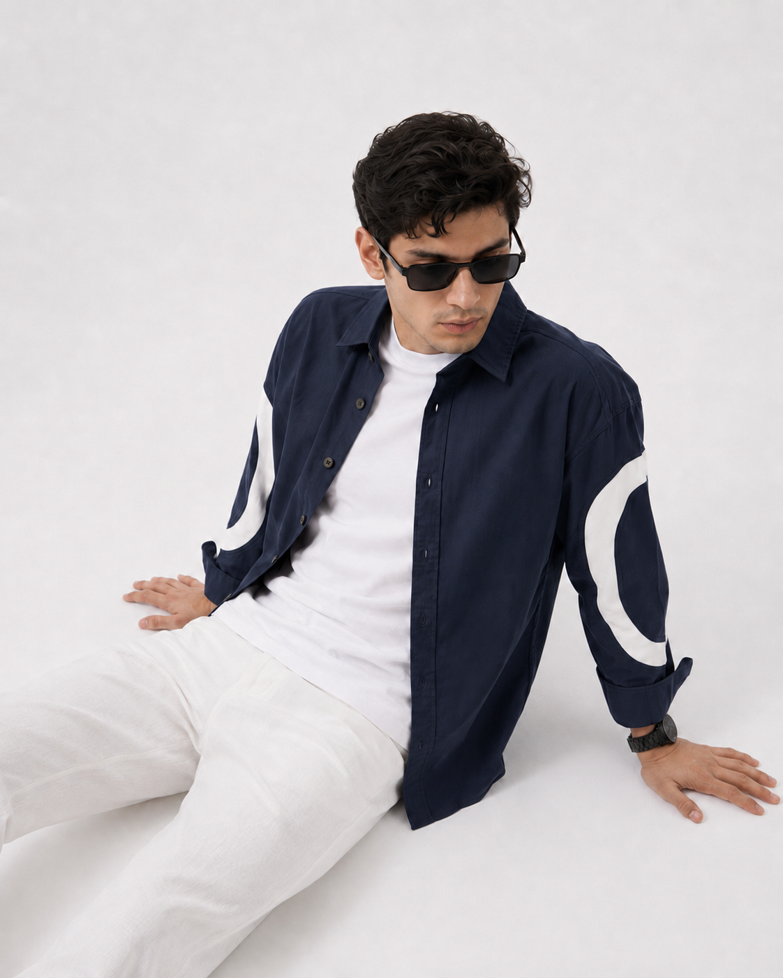 Model wearing GKSEN navy cotton shirt with off-white curved sleeve panels layered over a white T-shirt