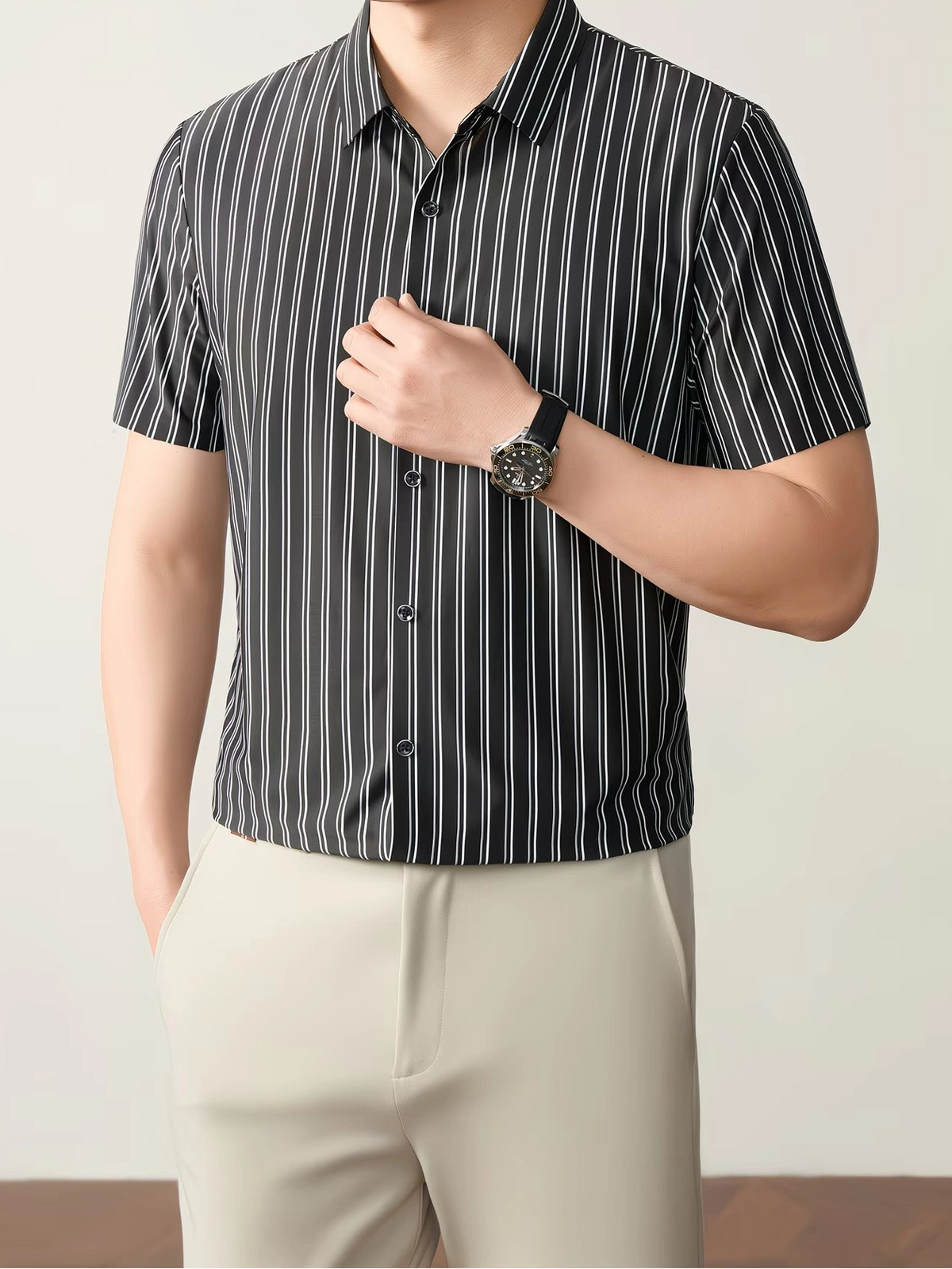 GKSEN black vertical stripe men’s shirt shown in a front model pose with short sleeves, black buttons, and light trousers.