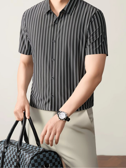 GKSEN men’s shirt in black and white vertical stripes shown in a front model pose with short sleeves, black buttons, and travel bag styling.