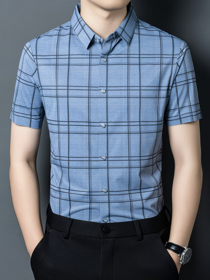GKSEN denim blue check men’s shirt shown in a front model pose with short sleeves, light buttons, black trousers, and windowpane check pattern.