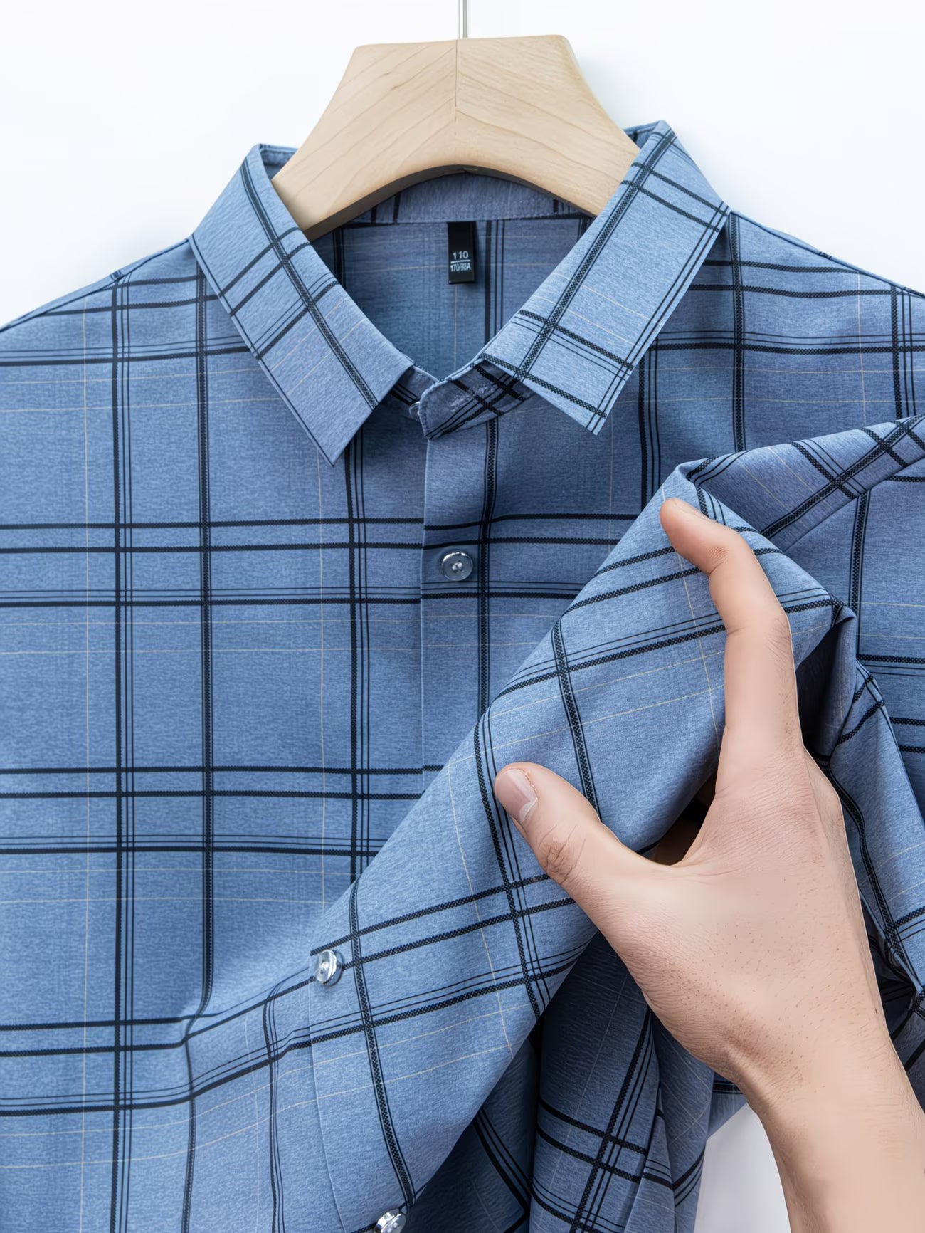 Close hanger view of the GKSEN denim blue windowpane check men’s shirt showing the collar, buttons, folded sleeve detail, and grid check pattern.