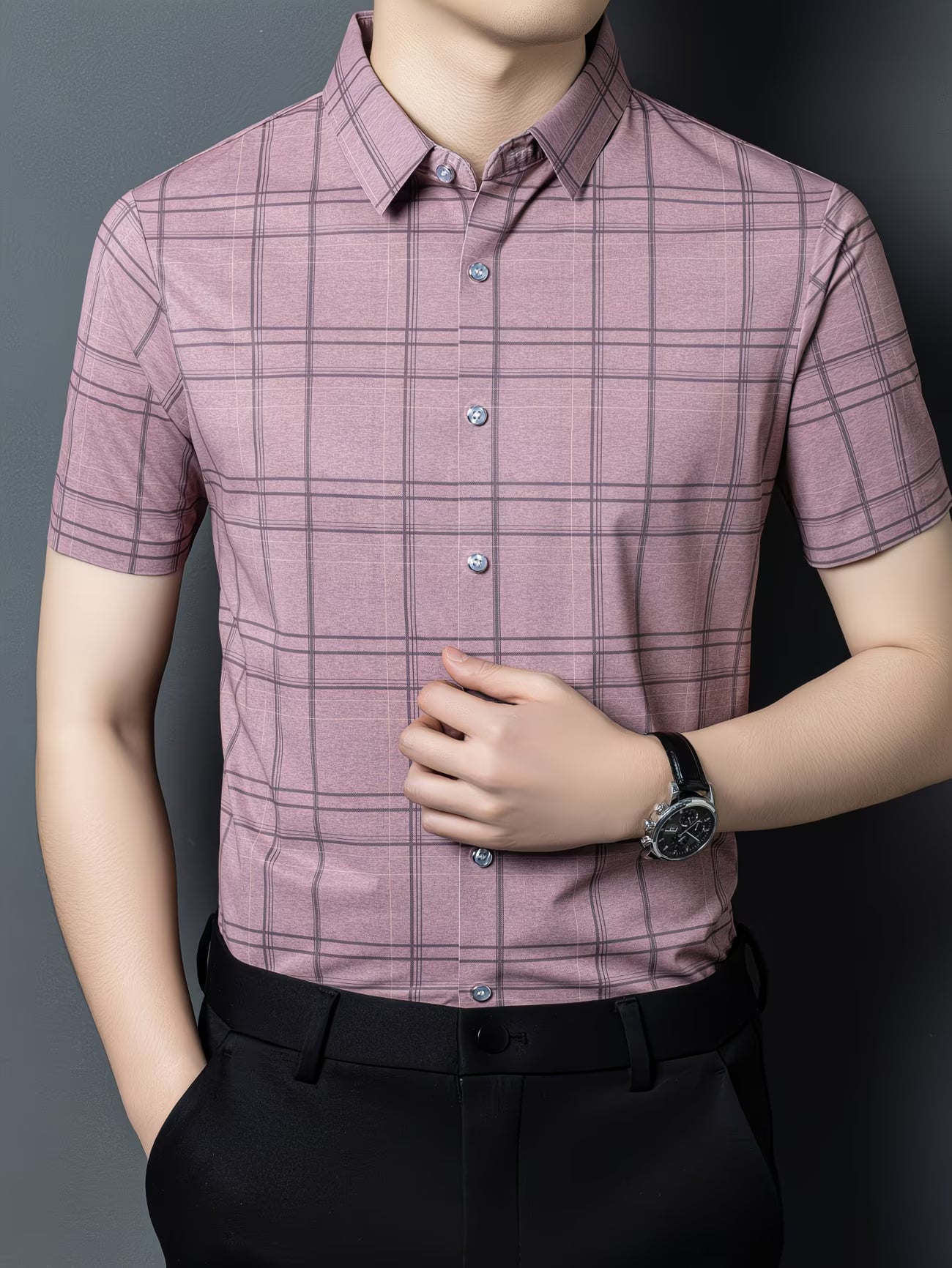 GKSEN mauve pink checked men’s shirt shown from the front with short sleeves, grey check lines, and the model adjusting the shirt.