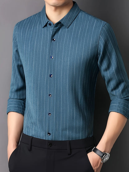 GKSEN petrol blue vertical stripe men’s shirt shown in a side-front model pose with black trousers and rolled sleeves.