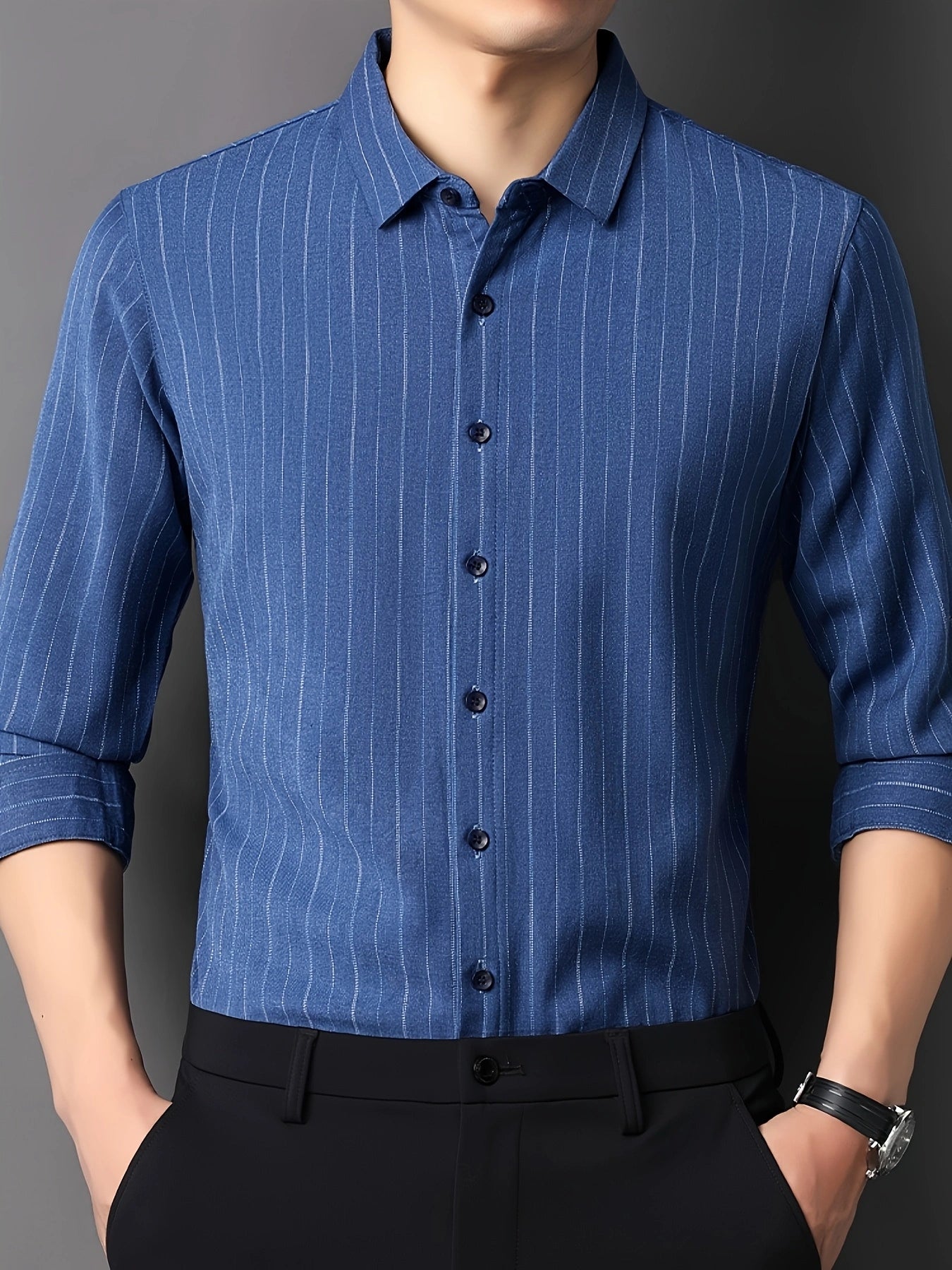 GKSEN royal blue pinstripe men’s shirt shown from the front with rolled sleeves and hands near the pockets.