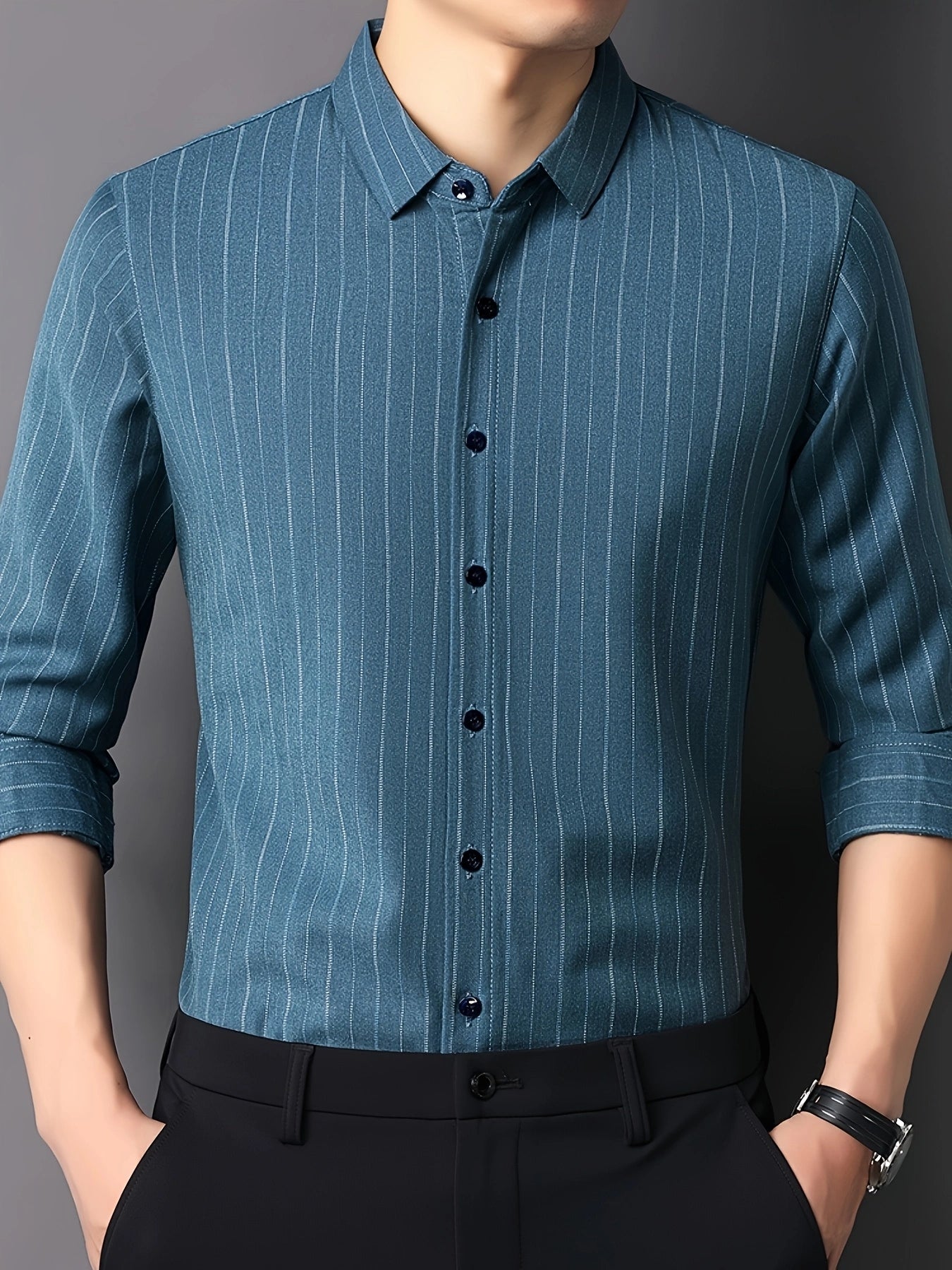 GKSEN men’s shirt in teal blue vertical stripes shown in a front view model pose with rolled sleeves and watch detail.