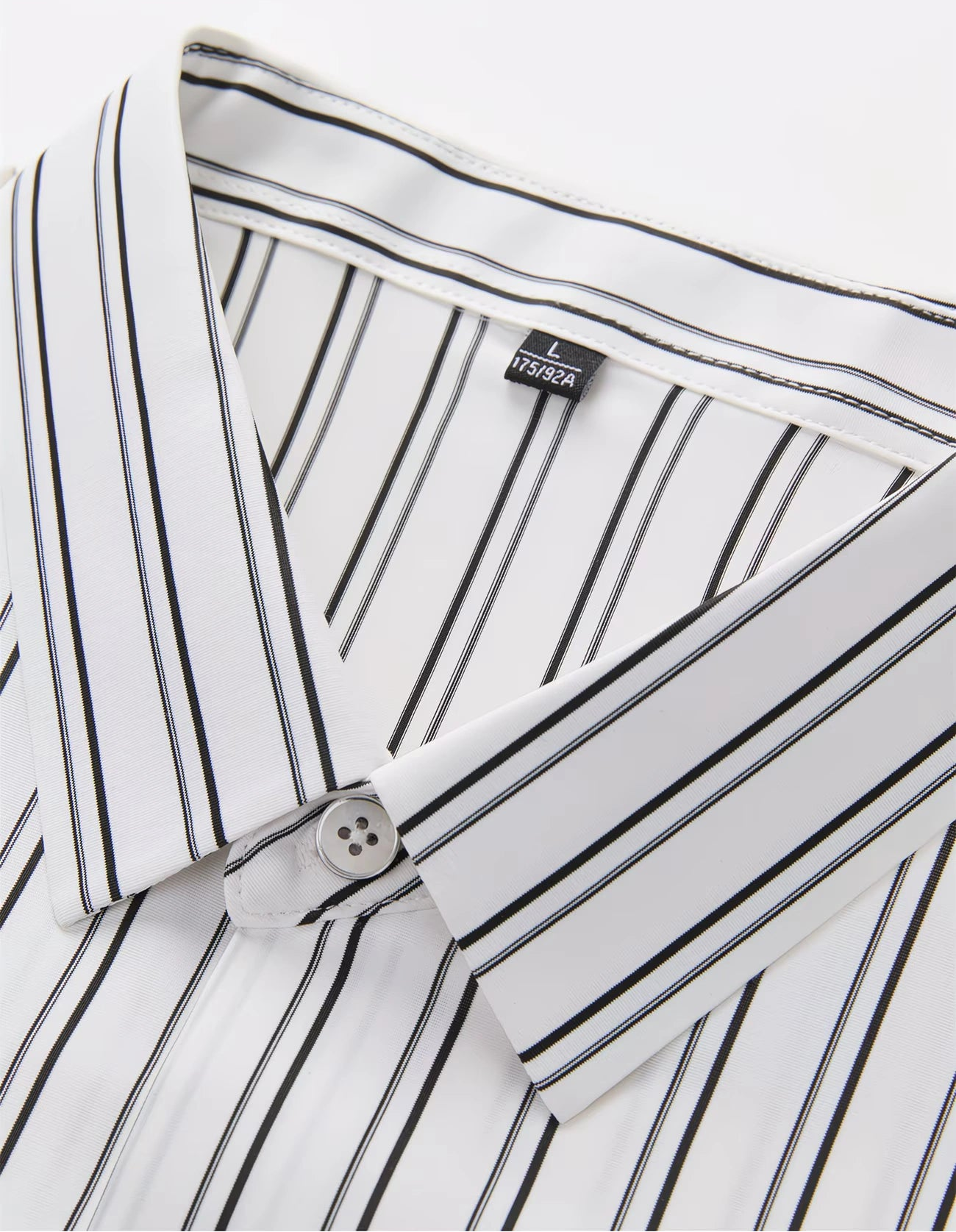 Close-up collar view of the GKSEN white black pinstripe men’s shirt showing the collar, button, inner neckline, and stripe alignment.