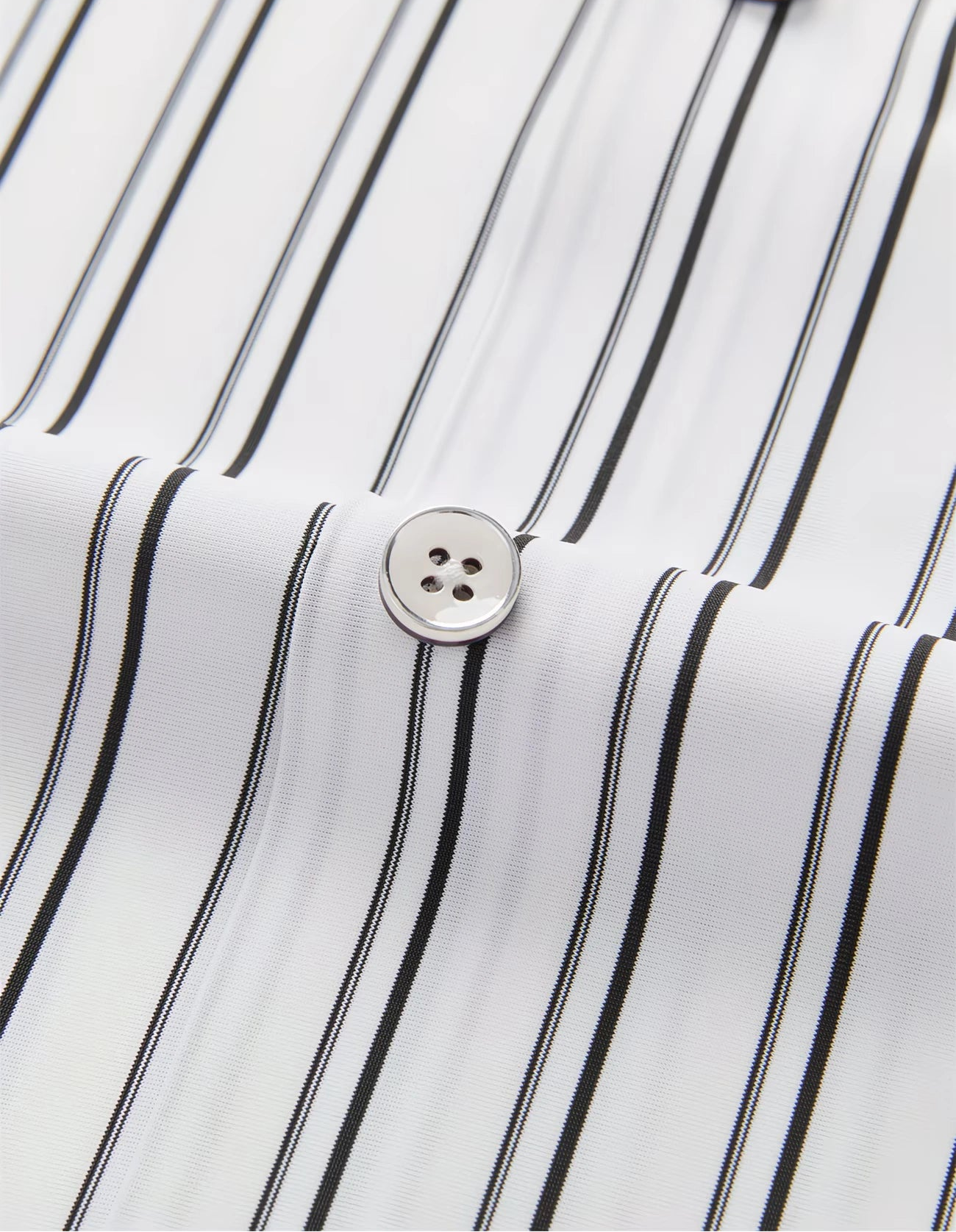 Close-up view of the GKSEN white black striped men’s shirt showing the fabric texture, vertical stripe pattern, and button detail.