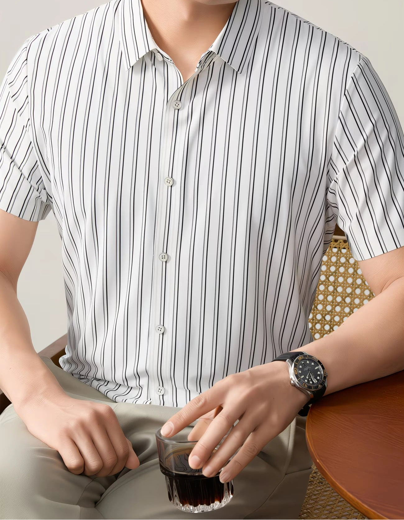 GKSEN white black striped men’s shirt shown in a seated front view with short sleeves, light buttons, and smart casual styling.