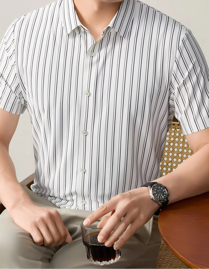GKSEN white black striped men’s shirt shown in a seated front view with short sleeves, light buttons, and smart casual styling.