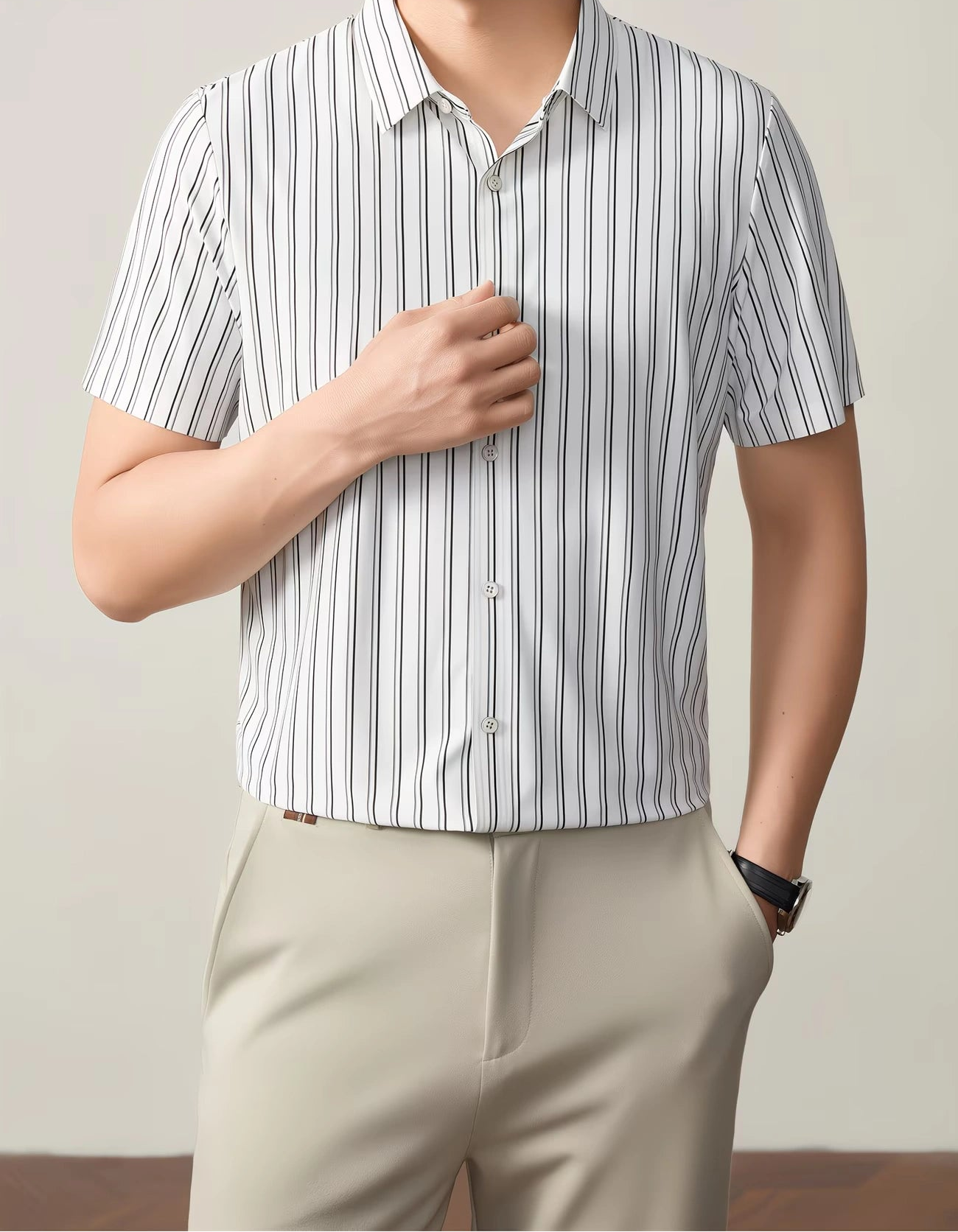 GKSEN white black vertical stripe men’s shirt shown from the front with the model hand near the button placket and collar detail visible.