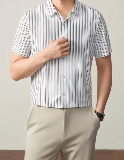 GKSEN white black vertical stripe men’s shirt shown from the front with the model hand near the button placket and collar detail visible.