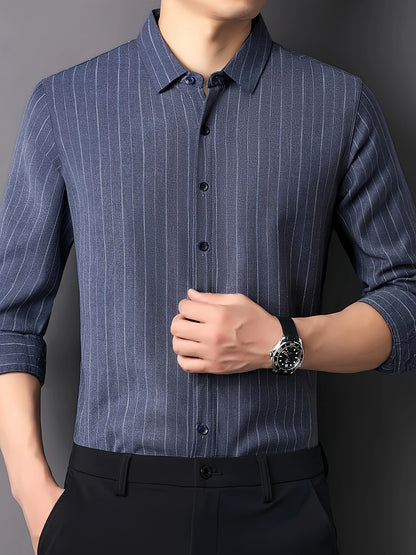 Model wearing GKSEN steel blue striped men’s shirt with vertical pinstripes, tucked styling and smart casual wristwatch pose.