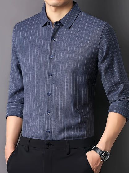 Angled front view of GKSEN steel blue vertical stripe men’s shirt styled with black trousers and rolled sleeves.