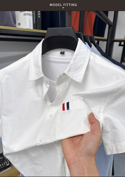 Close view of GKSEN men's white Oxford cotton short sleeve shirt showing chest pocket and tricolor accent detail